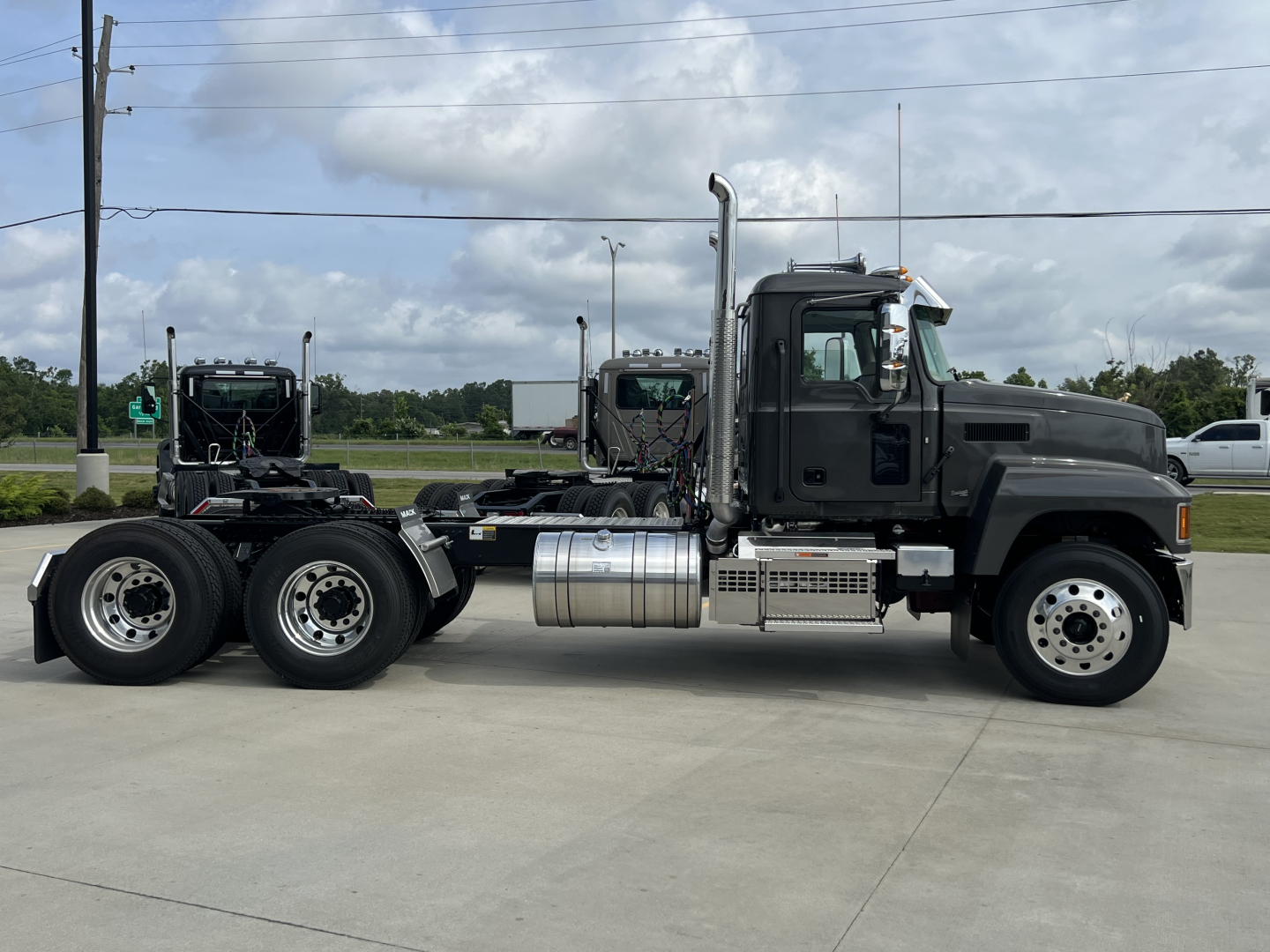 Mack PI64T truck side view showing cab, fuel tanks, exhaust stack, and dual rear axles.