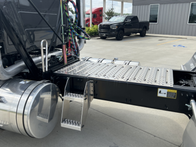 Truck chassis and steps with metal platform, fuel tank, and plumbing lines visible. No readable model-specific text on the image; generic industrial truck components visible.