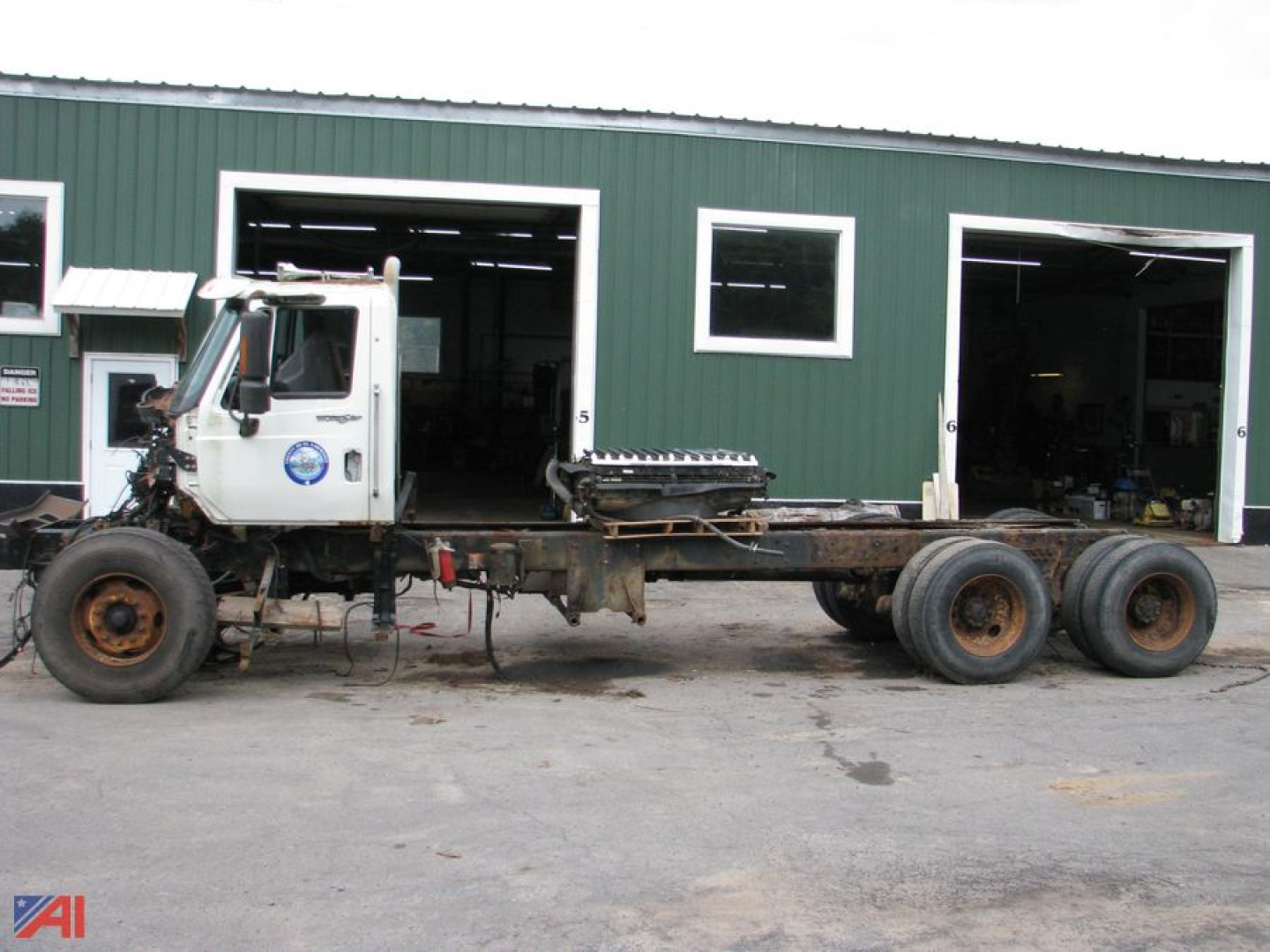 2013 International SF667 WorkStar 7600 cab and chassis truck with long bare frame and dual rear axles, side view.