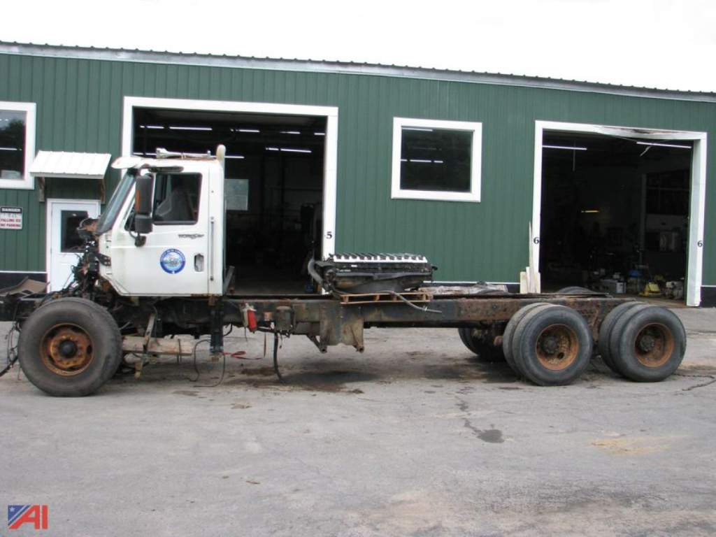2013 International SF667 WorkStar 7600 cab and chassis truck with long bare frame and dual rear axles, side view.