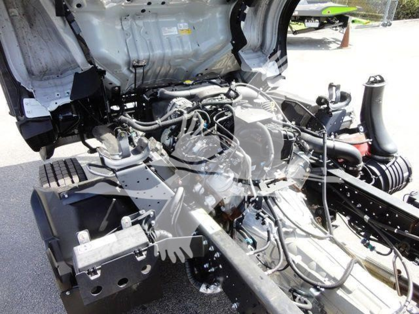 Isuzu NPR HD engine bay view showing exposed engine with hoses and components