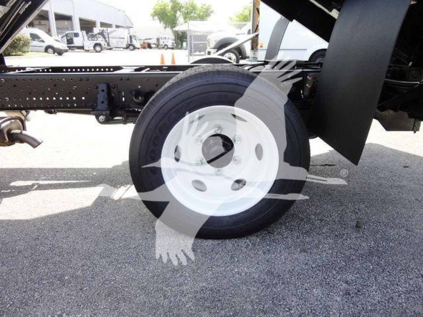 Isuzu NPR-HD truck chassis showing a white steel wheel and tire, with frame and hitch components visible.