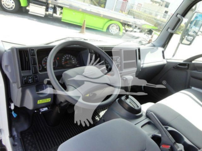 Isuzu NPR HD truck cockpit interior showing steering wheel, dash gauges, center console, and large infotainment screen.