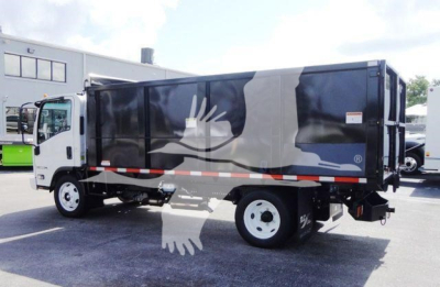 Isuzu NPR-HD dump truck in side view with graphic artwork on cargo bed, showing cab and chassis