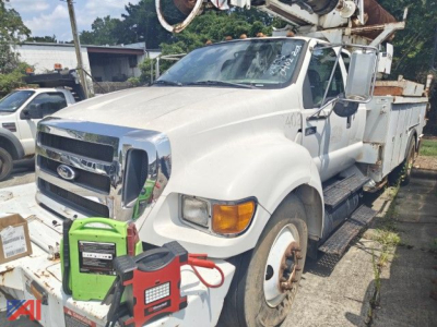 Ford F-750 Super Duty bucket truck with boom equipment and utility body, front view, white cab, green portable generator and red jumper near bumper.