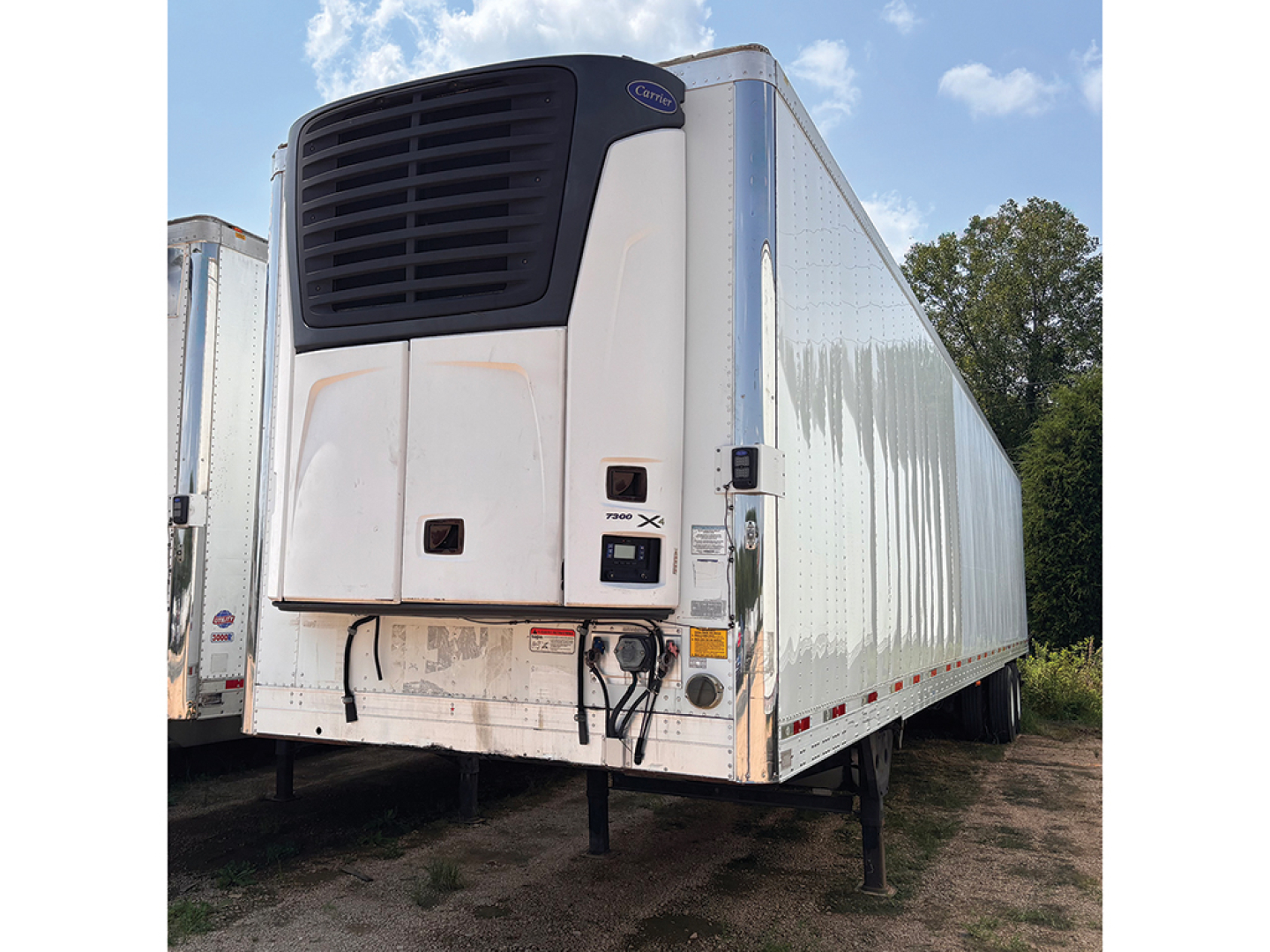 Utility reefer trailer with CARRIER refrigeration unit showing front panel and hitch, 2016 model, white and aluminum sides.