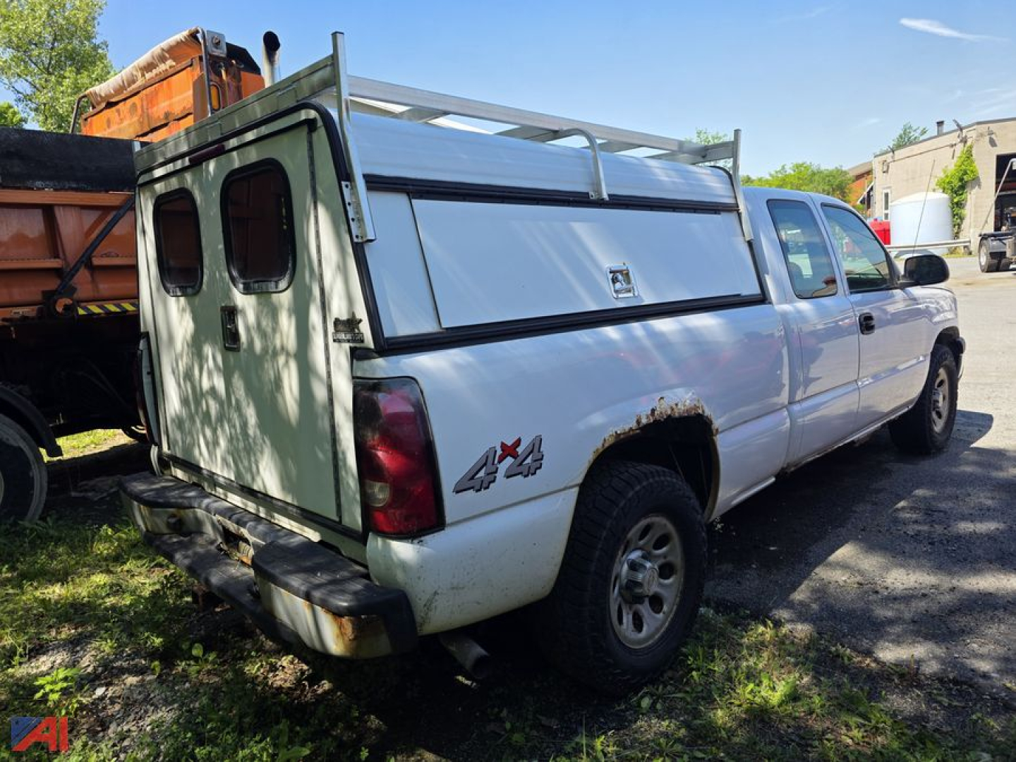 Chevrolet Silverado 1500 pickup with utility cap, 4x4 badge, extended cab, white with green rear canopy, rear view showing tailgate area and truck bed utility cap