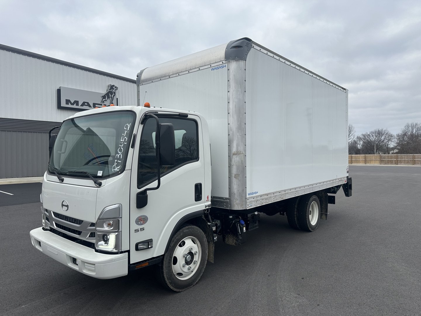 Box truck in a lot showing a white cab and a white cargo box, front-left view, with Honda/Hino badge on grille and side mirrors; no visible text on the truck body other than generic labels.