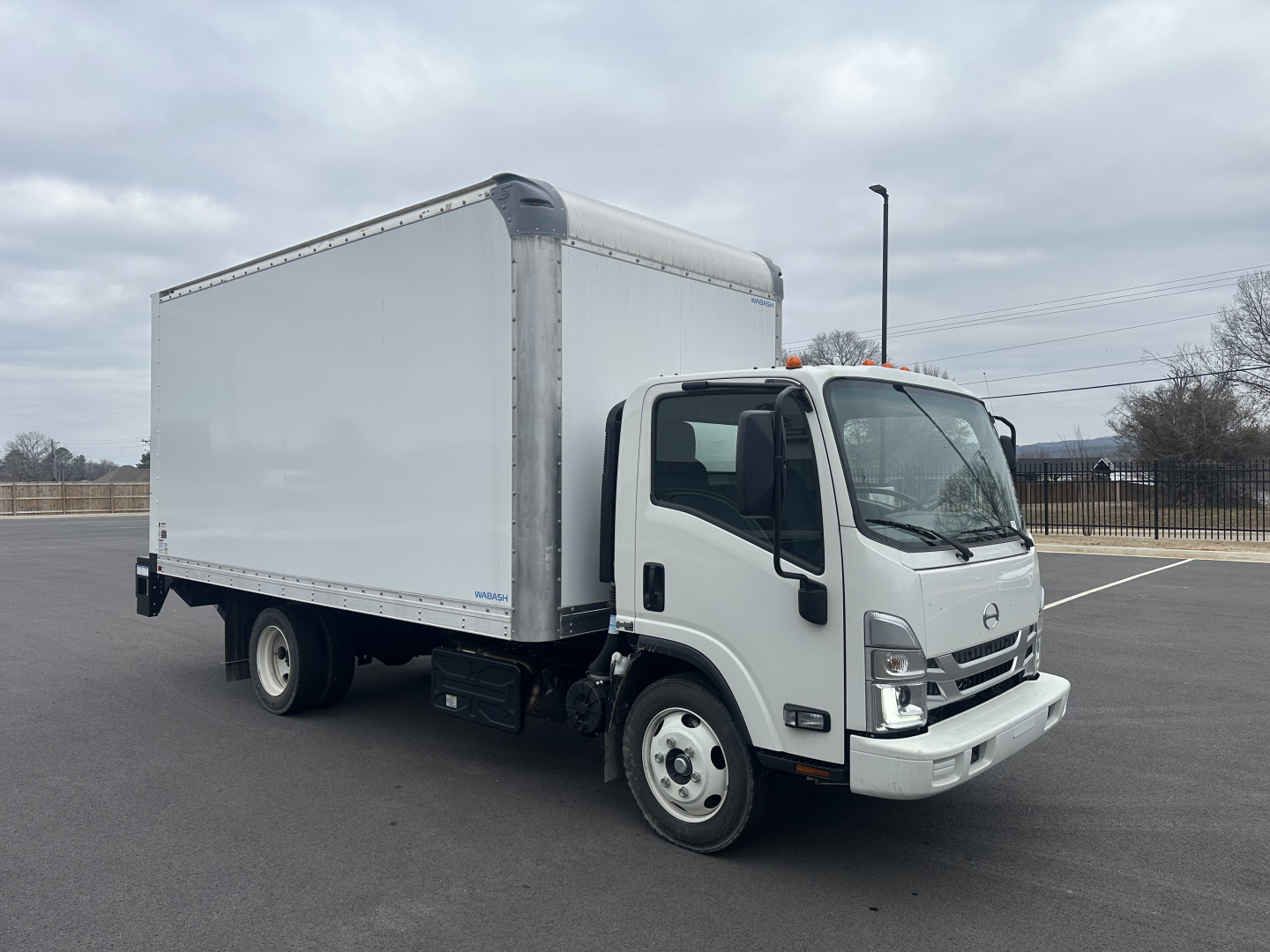 Isolated view of a white medium-duty box truck with a cargo box, front cab, and two-tone mirrors. No legible labels visible on the truck body.