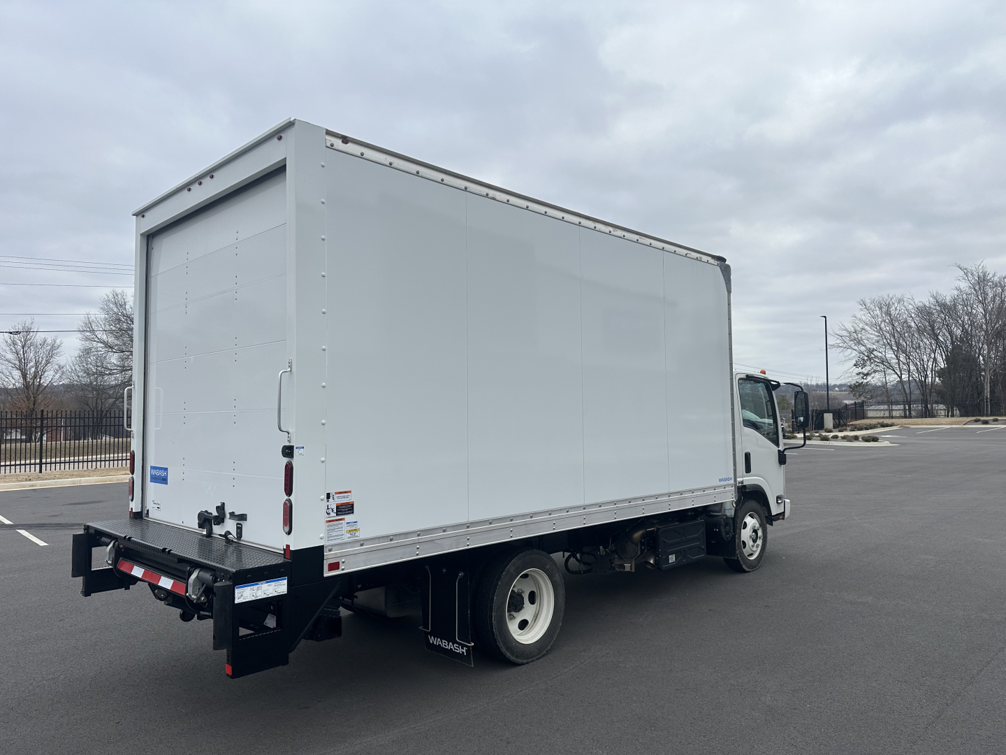 Box truck with white cargo box and cab, rear view showing cargo area and bumper.