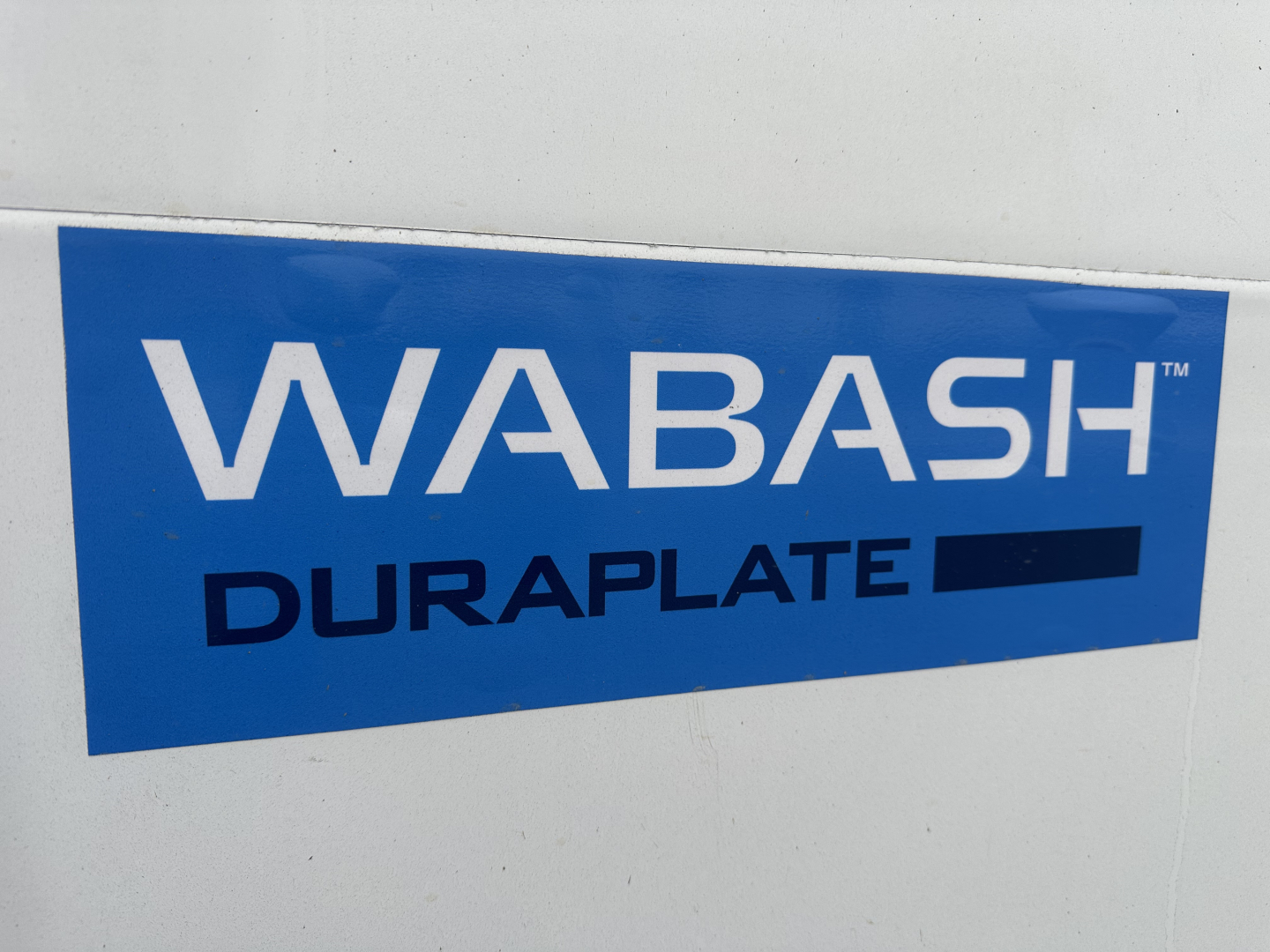 WABASH DURAplate blue logo sticker on white truck side wall.