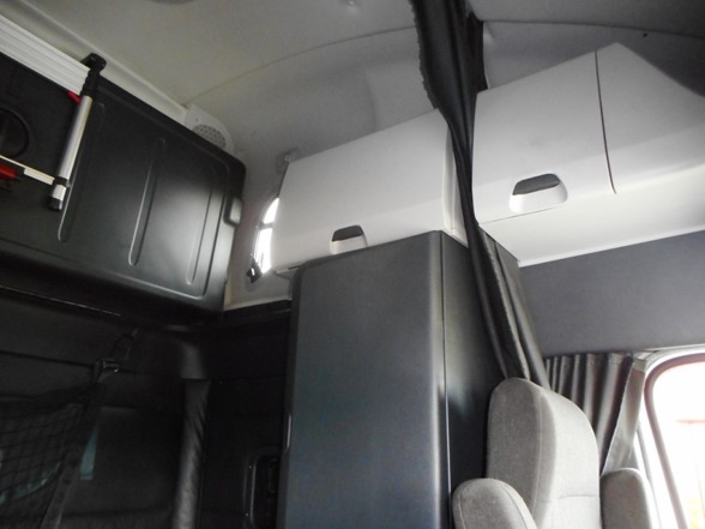 Cab interior of a 2023 Freightliner Cascadia 126 showing sleeper area and cabin partition.
