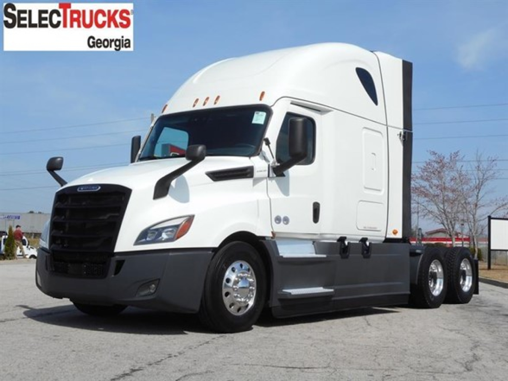 Freightliner Cascadia 126 sleeper tractor in white, side view with logo dealership graphics in corner.