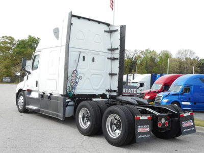 Freightliner Cascadia 126 tractor rear and cab side showing 6-wheel rear axle, white exterior, trailer connection area, no visible text on doors.
