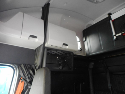 Freightliner Cascadia truck cab interior showing overhead storage compartments and sleeping area.