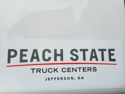 Truck center sticker reading PEACH STATE TRUCK CENTERS JEFFERSON, GA on the side of a Freightliner Cascadia cab.