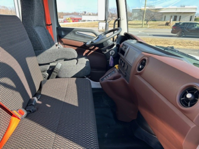 Cab and chassis interior of a 2025 Hino L7 showing the driver seat, passenger seat, steering wheel, dashboard, and center console with brown/tan trim.