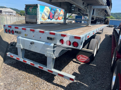 Flatbed trailer rear view showing LED taillights and Dorsey mudflap with extendable trailer deck.
