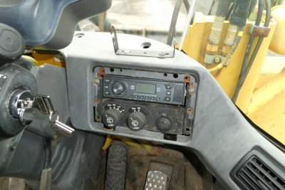 Kawasaki 65TMV cab dashboard showing radio console and control dials.