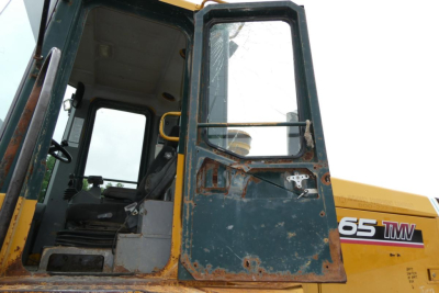 Kawasaki wheel loader cabin door and window with visible 65TMV branding on the machine