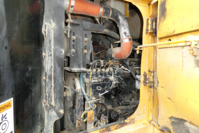 Kawasaki 65TMV wheel loader engine compartment with visible hoses and components.