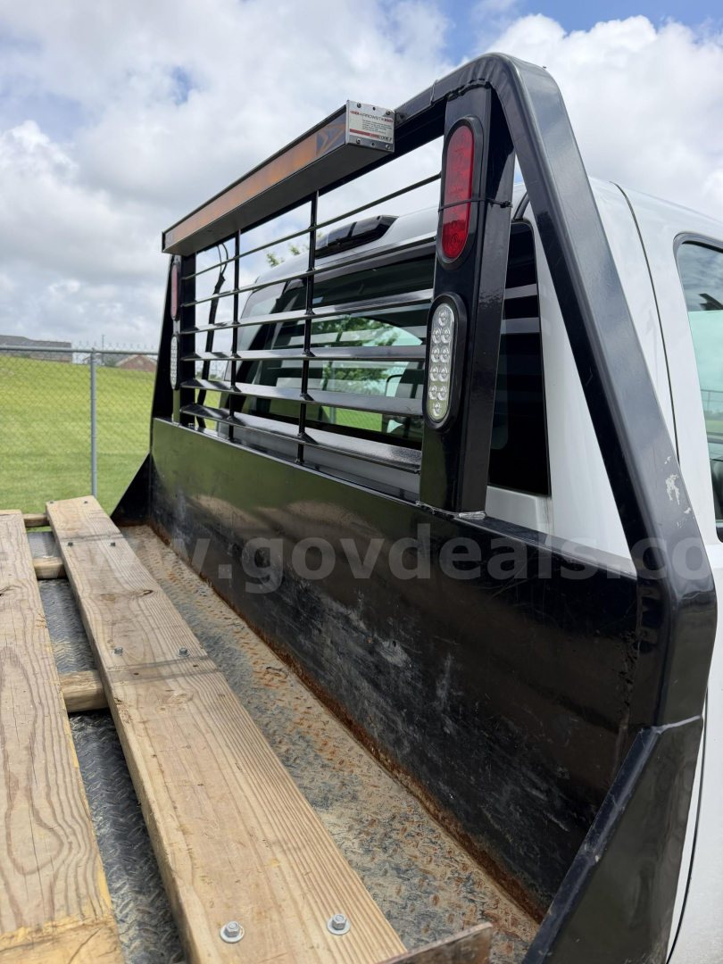 GMC Sierra 3500HD truck rear with flatbed and Ridge-backed headache rack, side view showing cargo area and wooden planks.