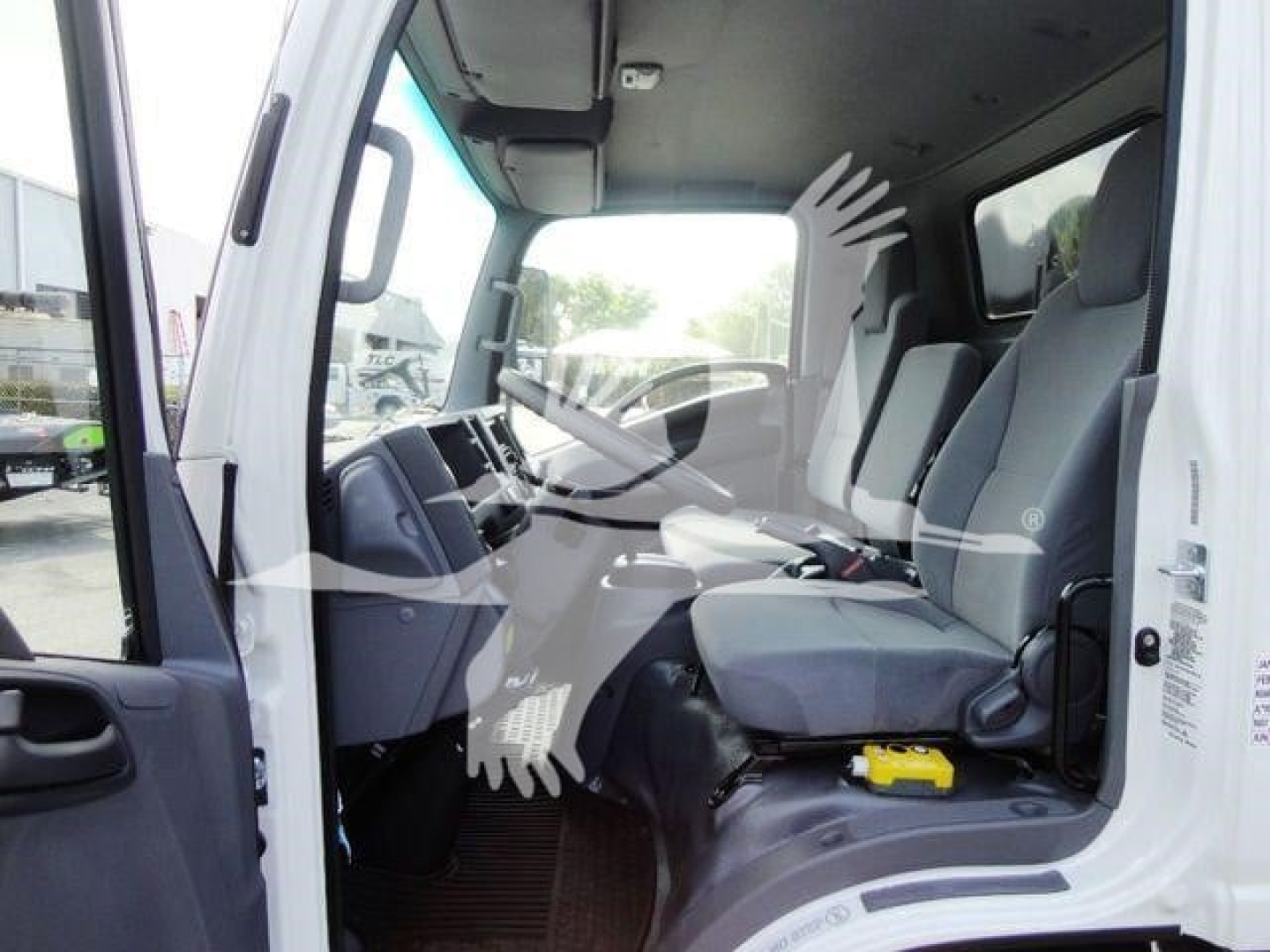 Isuzu NPR HD cab interior with steering wheel, dashboard, and front seats visible; no visible labels or text legible other than general cabin features.