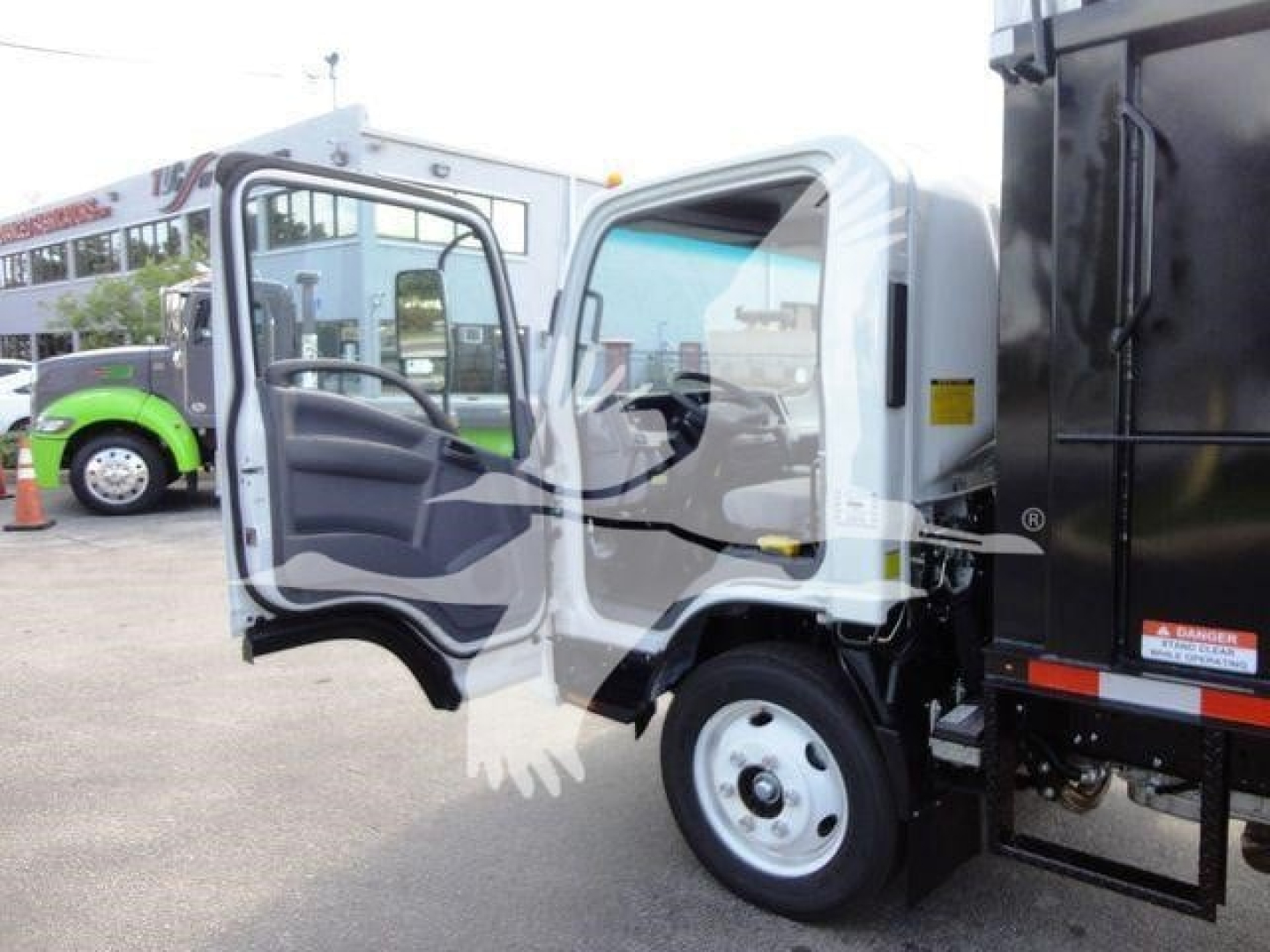 Isuzu NPR HD dump truck cab open showing driver-side door and interior details.