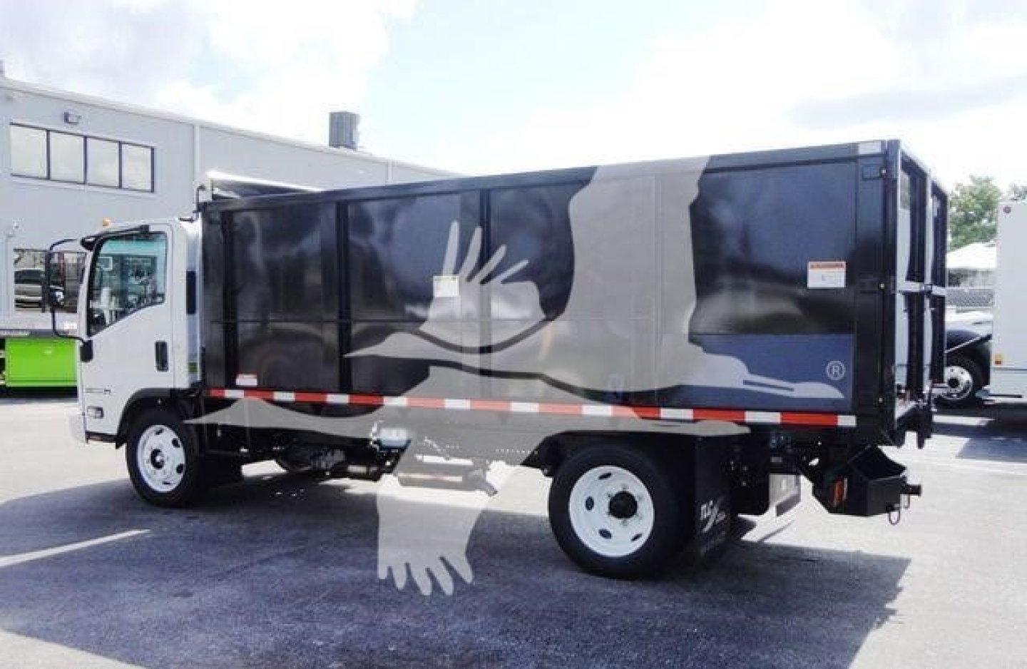 Isuzu NPR HD dump truck side view showing cargo bed and graphic artwork on the body.