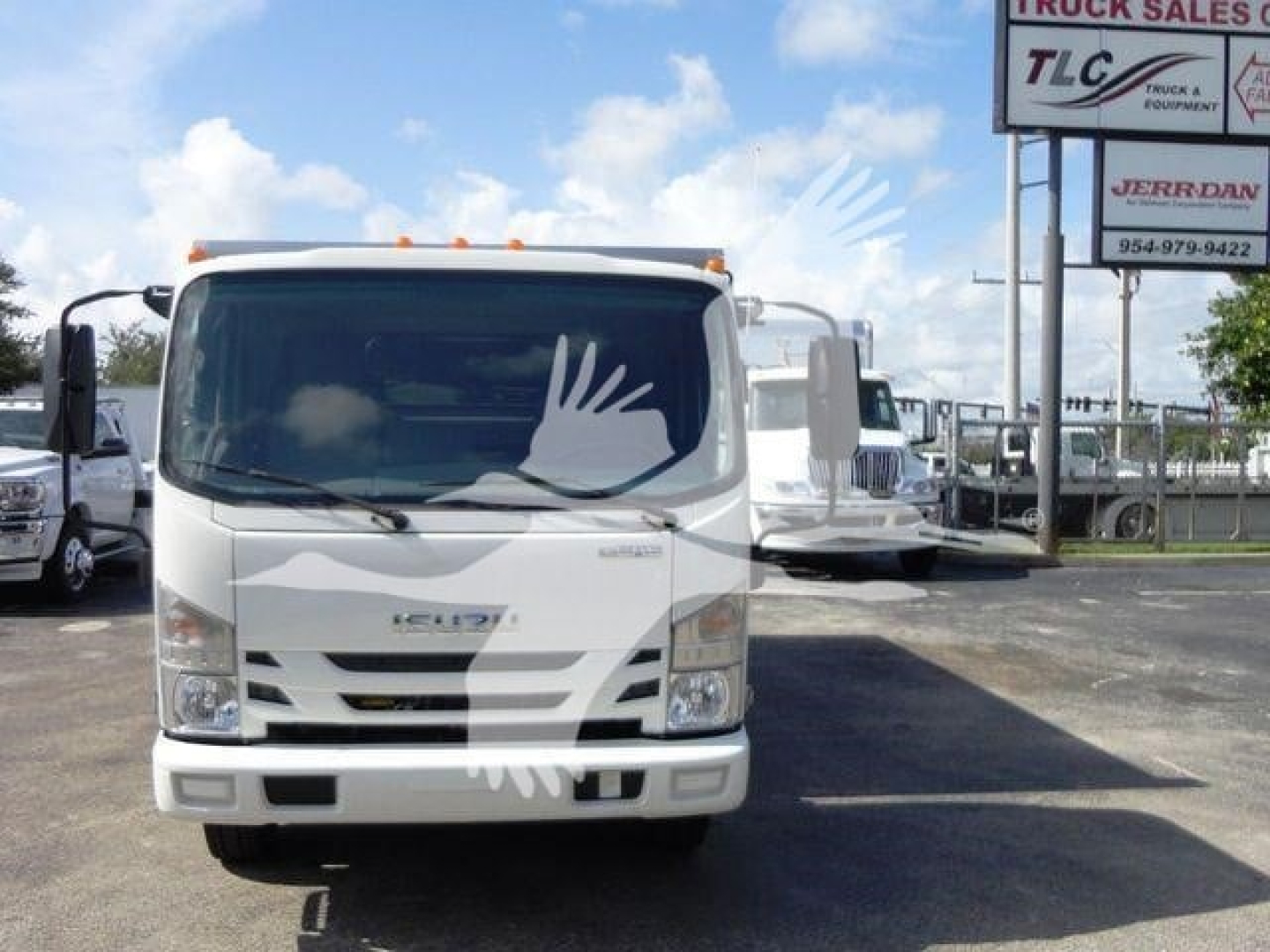 Isuzu NPR HD dump truck in a dealership lot, front view, white cab with orange clearance lights, stock number J03502FM visible on sign