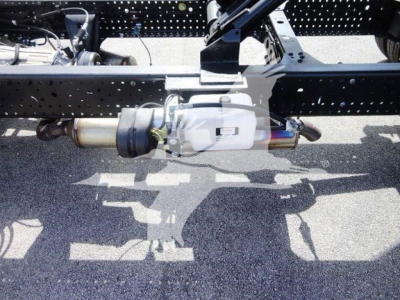 Isuzu NPR HD truck chassis showing rear drive shaft and differential with exhaust pipe