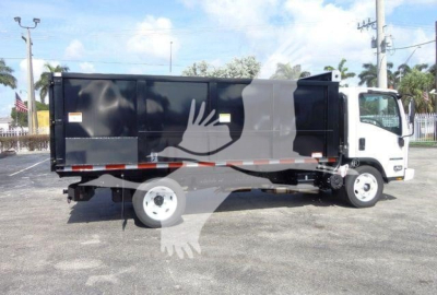 Isuzu NPR-HD dump truck side view showing cargo bed and cab in a parking lot.