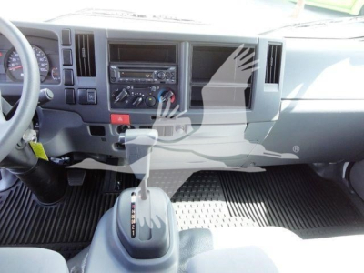 Isuzu NPR-HD truck interior showing dashboard with stereo, climate controls, gear selector, and ribbed floor mats.