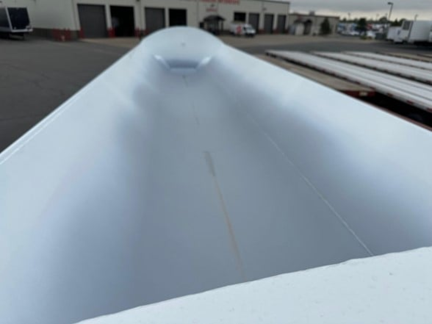 Front view of a new Jet Side Dump trailer showing smooth painted aluminum side with slight crease at top center.