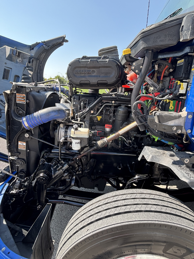 Kenworth T680 engine bay showing air intake hoses and engine components.