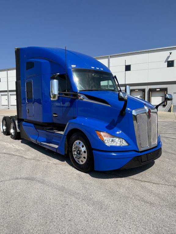 Kenworth T680 sleeper truck in blue, front-right view with aerodynamic hood and chrome grille.