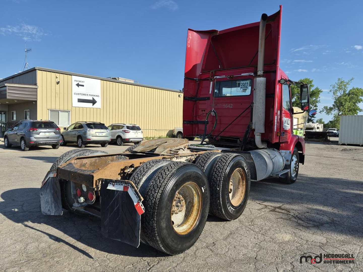 Volvo semi tractor day cab rear view showing fifth wheel and dual rear axles with mud flaps.