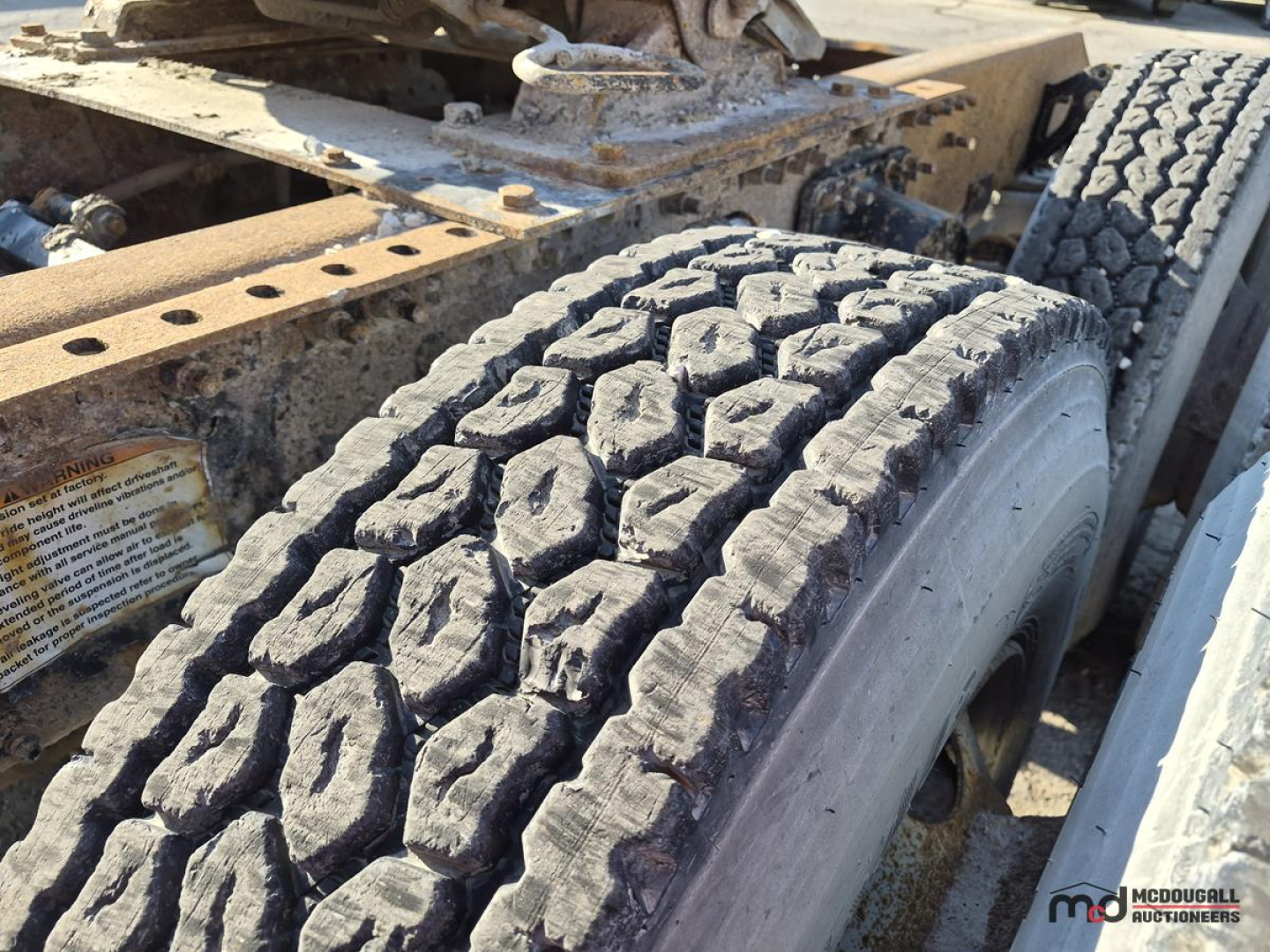 Volvo truck chassis with dual rear tires and rugged tread showing on a worn-in peg, visible frame rails and suspension components in the image.