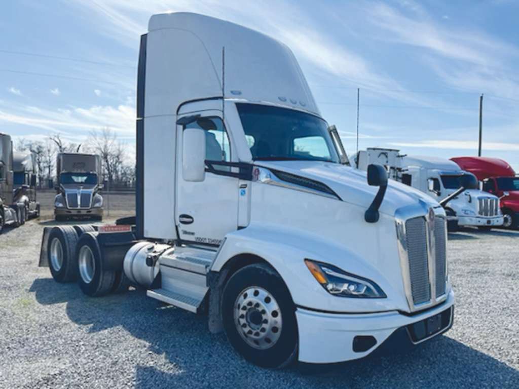 Kenworth T-680 Next Gen conventional daycab tractor in white, side view displaying sleeper cab, front grille, and dual rear axles.