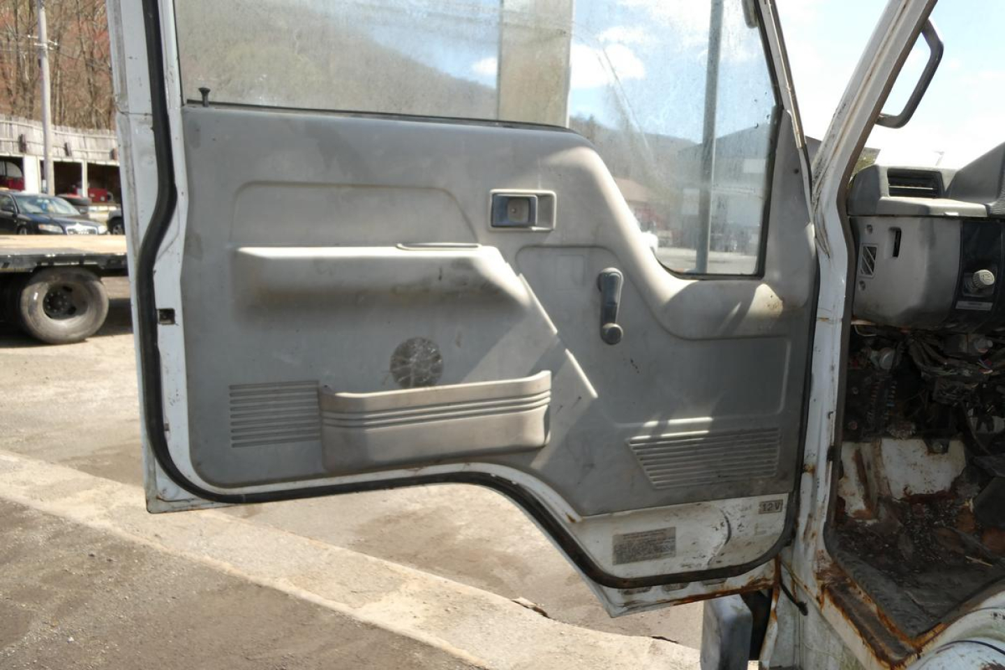 Truck door interior panel with window and manual window crank, hinges, and control handle.