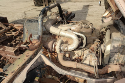 Mitsubishi FH engine bay showing diesel engine with intake piping and turbocharger, exposed hoses and metal frame.