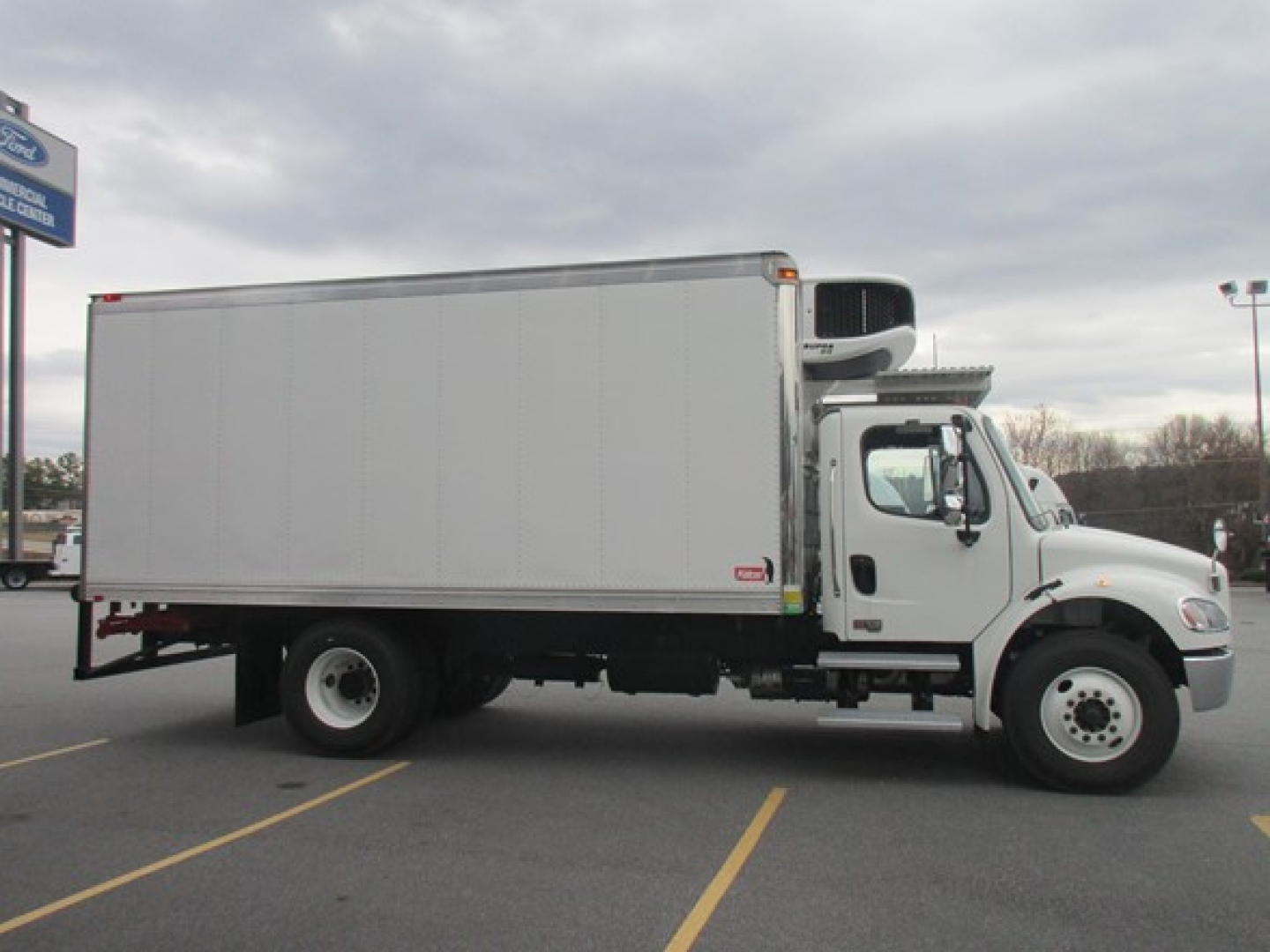 Freightliner M2 106 Plus refrigerated truck side view showing cargo box and refrigeration unit on cab roof.