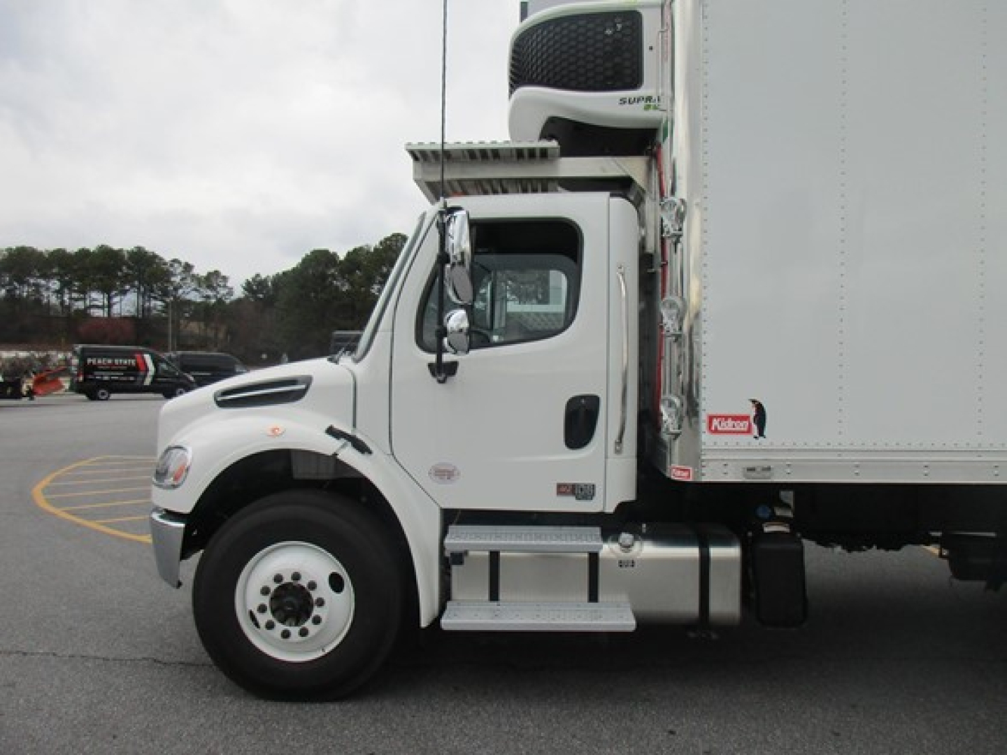 Freightliner M2 106 Plus refrigerated truck side view showing cab and cargo box