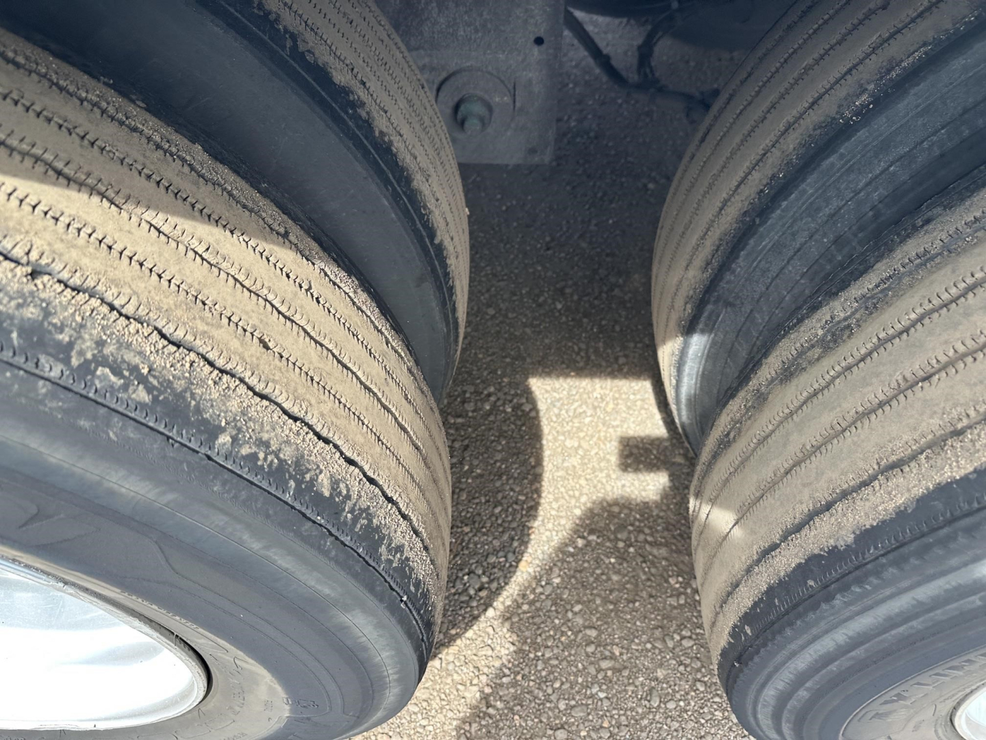 Trailer tires and trailer frame viewed from above showing dual tires and gap between wheels.
