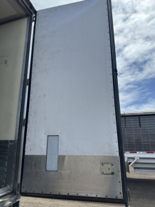 Utility 3000R trailer rear door and side panel showing metal lower panel and riveted seams.