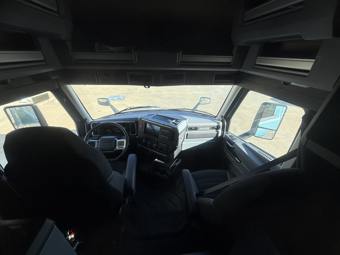 Cab interior of a new 2026 Mack PR64T76H truck showing dashboard, steering wheel, and seats.