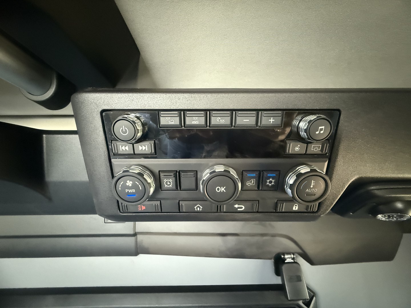 Mack PR64T76H dash panel showing control buttons and infotainment screen.