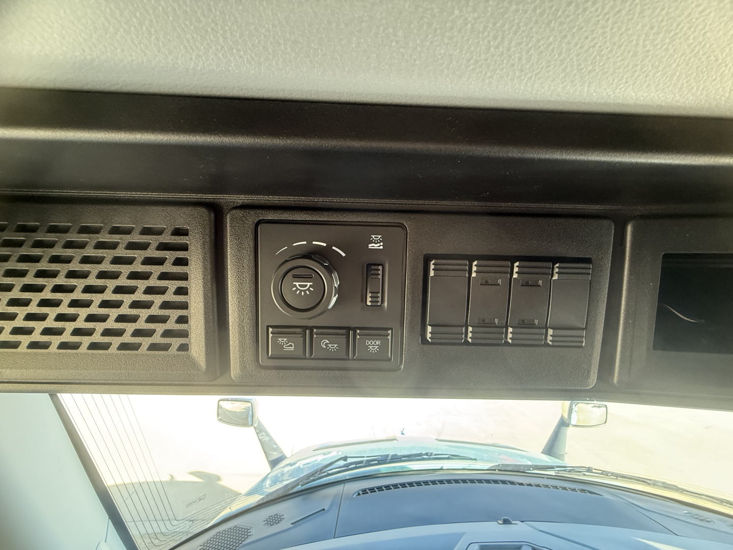 Mack PR64T76H interior dashboard panel with dimmer and switches, rectangular vents visible.