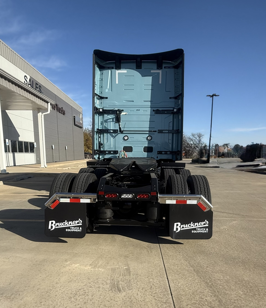 Truck rear view showing fifth wheel and dual rear axles of a new Mack PR64T76H conventional sleeper tractor.