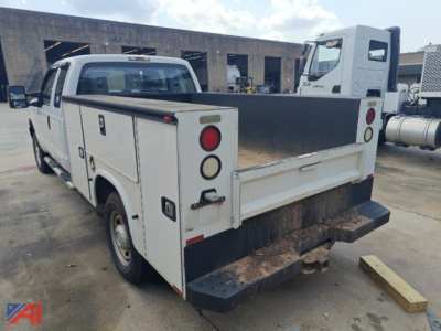 Truck bed with utility service body on a white 2016 Ford F-250 Super Duty, rear view showing tailgate, rear bumper with step, utility compartments, and dual rear wheels.